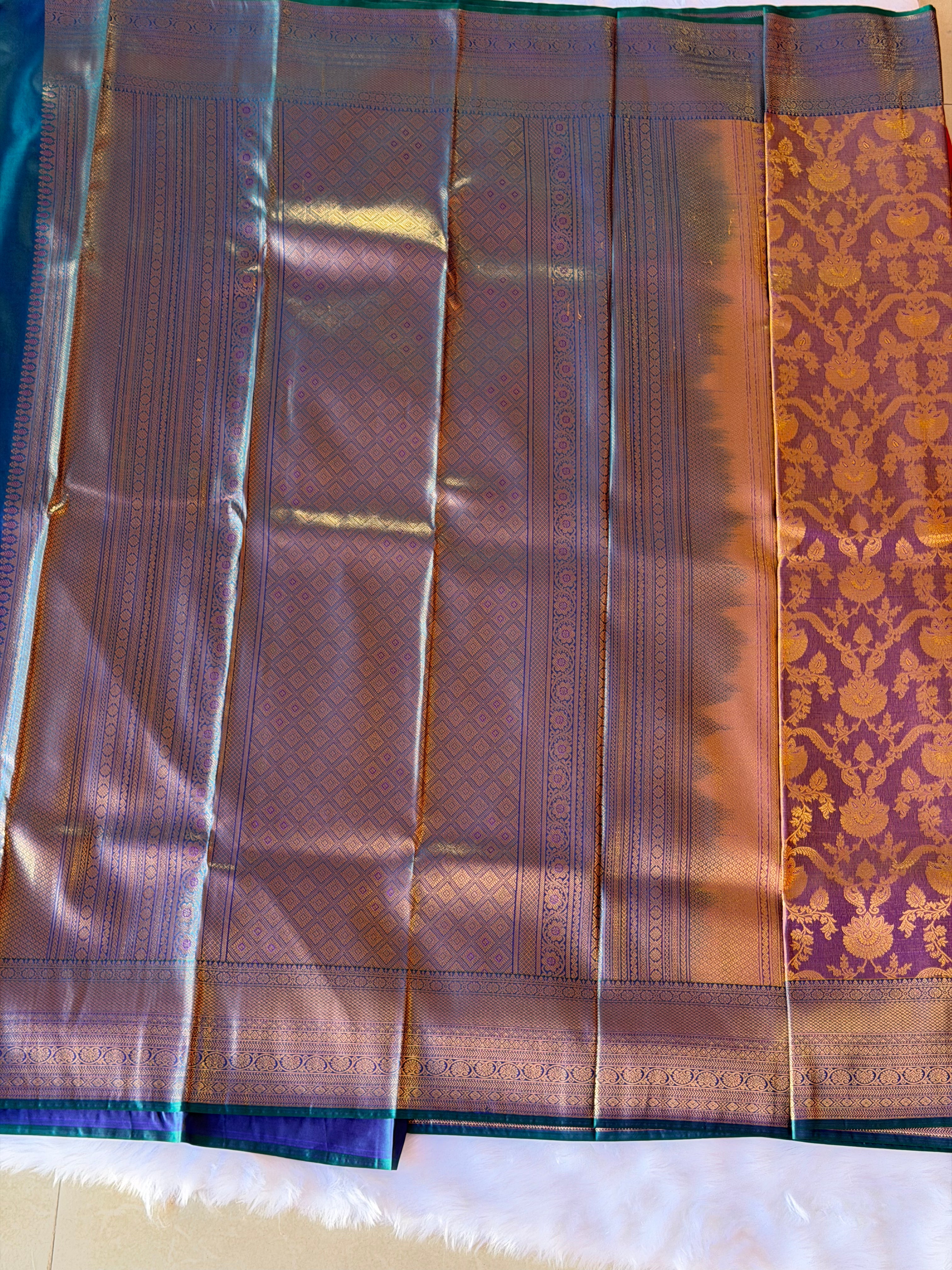 Teal blue geometric patterned zari border on rich mauve Kanchipuram polyester saree