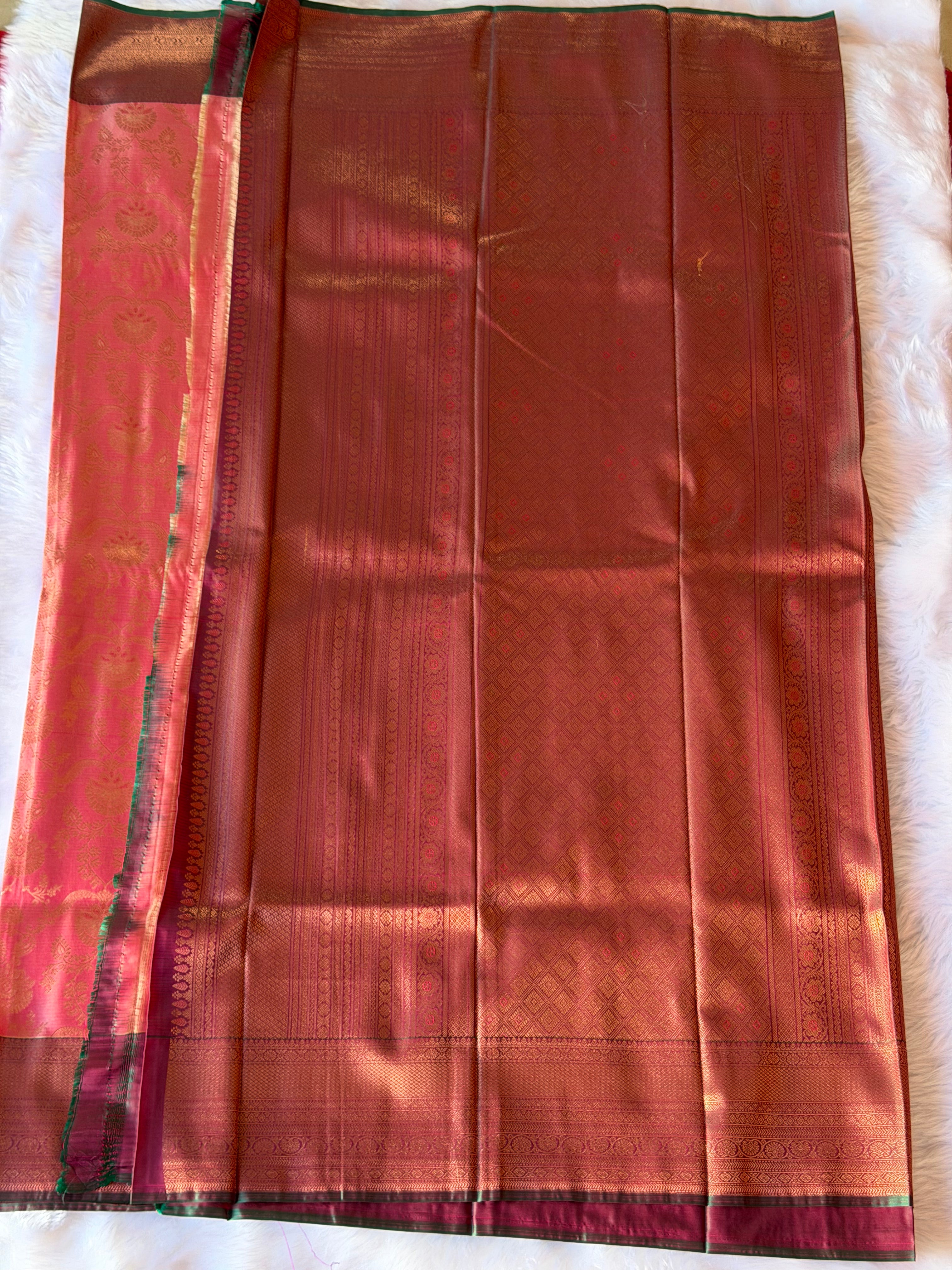 Broad bronze-gold border with green accent piping on soft peach Kanchipuram polyester saree